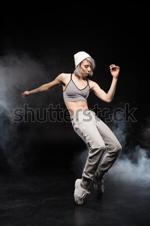 woman in sports clothing dancing on black Stock photo © LightFieldStudios