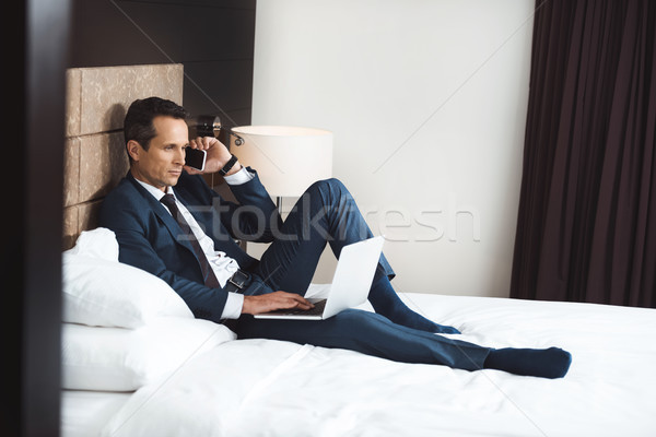 Foto stock: Empresário · cama · telefone · laptop · formal · terno