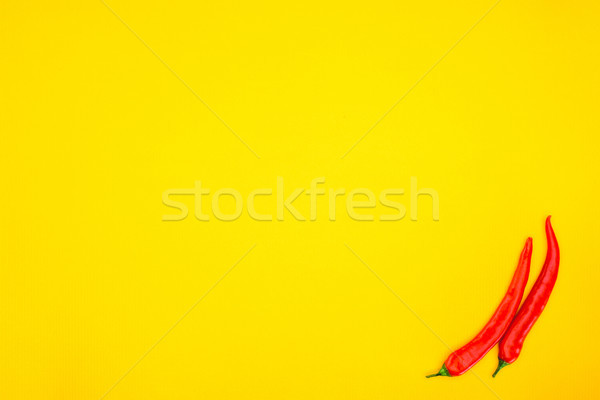 top view of raw red chili peppers isolated on yellow background Stock photo © LightFieldStudios