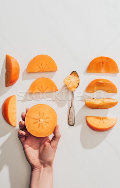 Afbeelding vrouw stuk persimmon hand Stockfoto © LightFieldStudios