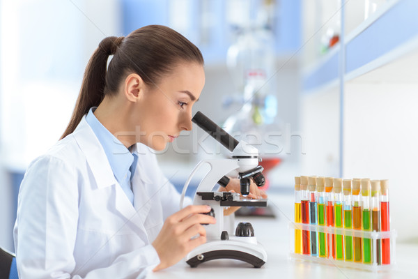 Side view of concentrated woman scientist working with microscope in laboratory  Stock photo © LightFieldStudios