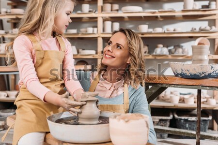 Happy mother looking at daughter beating egg in glass bowl with flour  Stock photo © LightFieldStudios