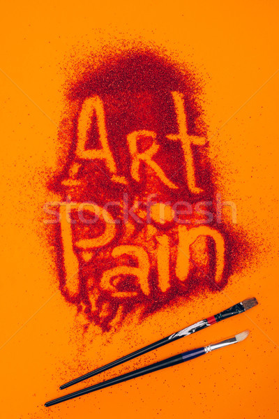 top view of art pain sign made of red sand and brushes isolated on orange Stock photo © LightFieldStudios