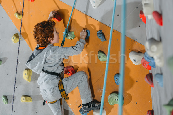 Little boy climbing wall with grips Stock photo © LightFieldStudios