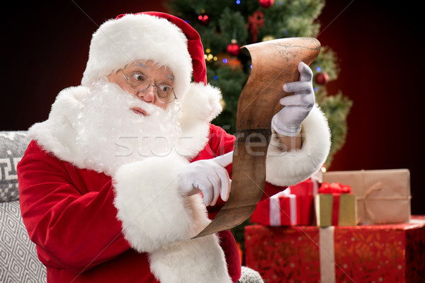 Santa Claus reading wishlist Stock photo © LightFieldStudios