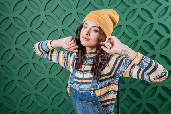 Woman posing in pullover, hat and overalls Stock photo © LightFieldStudios
