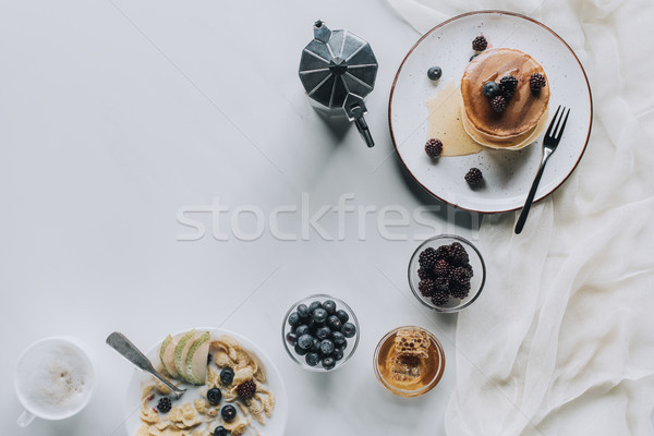 top view of tasty healthy breakfast with pancakes and cappuccino on grey Stock photo © LightFieldStudios