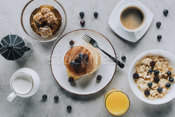 top view of tasty healthy breakfast with pancakes and muesli on grey Stock photo © LightFieldStudios