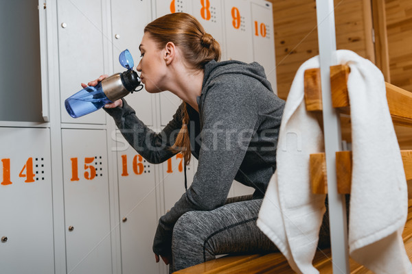 Mujer potable cantimplora sesión banco Foto stock © LightFieldStudios