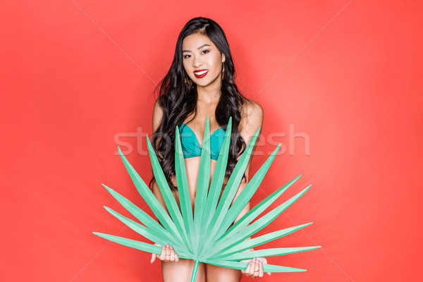 woman in swimsuit holding palm leaf Stock photo © LightFieldStudios