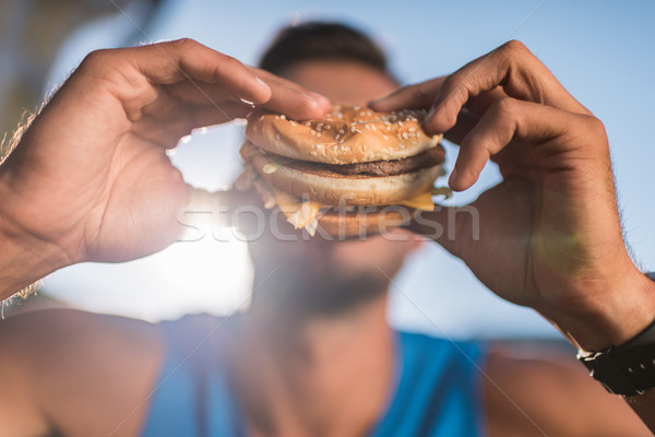 Om mananca hamburger vedere Imagine de stoc © LightFieldStudios