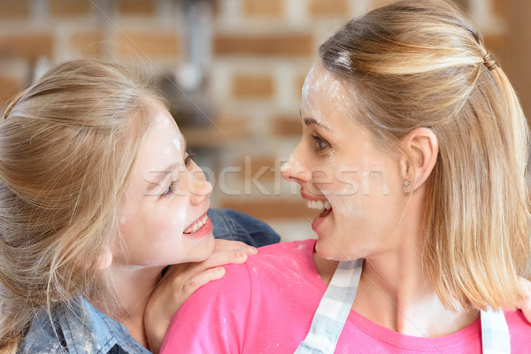 portrait of cheerful mother and daughter in flour in kitchen Stock photo © LightFieldStudios