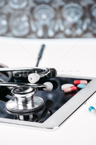 close up view of stethoscope on digital tablet and pills on white Stock photo © LightFieldStudios