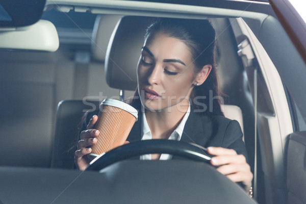 Woman driving and drinking coffee Stock photo © LightFieldStudios
