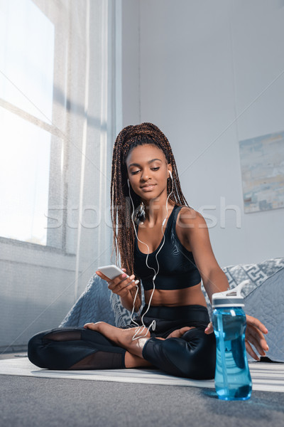 sportive woman with smartphone and water bottle Stock photo © LightFieldStudios