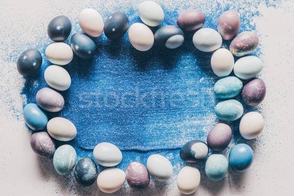 top view of painted easter eggs and blue sand on white surface Stock photo © LightFieldStudios