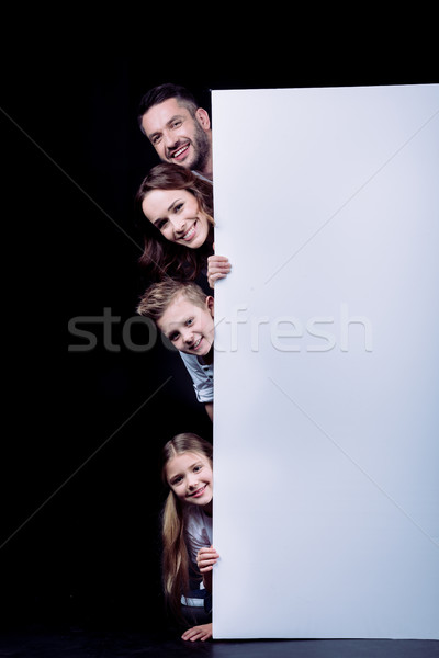 Happy family holding blank card Stock photo © LightFieldStudios