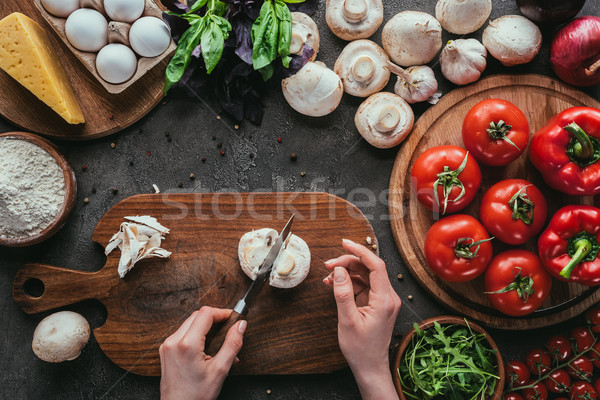 cropped shot of woman cutting mushrooms for pizza on concrete table Stock photo © LightFieldStudios