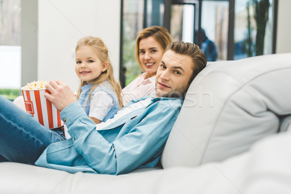 side view of family with popcorn looking at camera while watching film together at home Stock photo © LightFieldStudios
