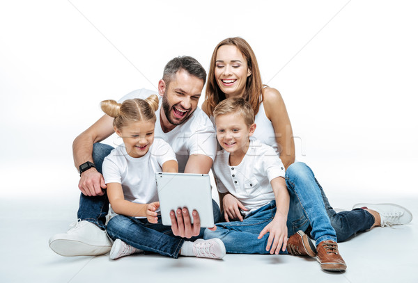 Smiling family using digital tablet Stock photo © LightFieldStudios