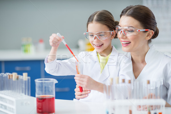 portrait of smiling woman teacher and girl student scientists making experiment in lab Stock photo © LightFieldStudios