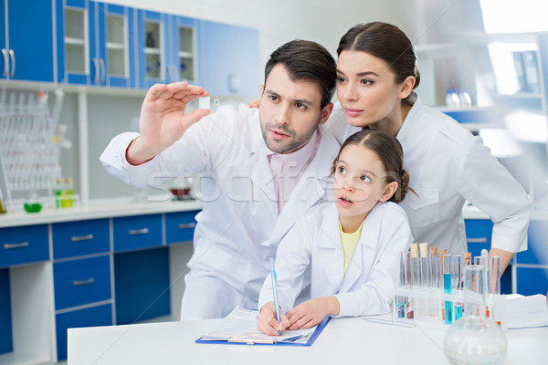 portrait of concentrated scientists looking at microscope slide in lab Stock photo © LightFieldStudios