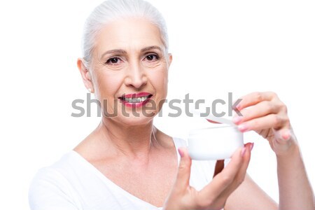 senior woman with anti-wrinkle cream  Stock photo © LightFieldStudios