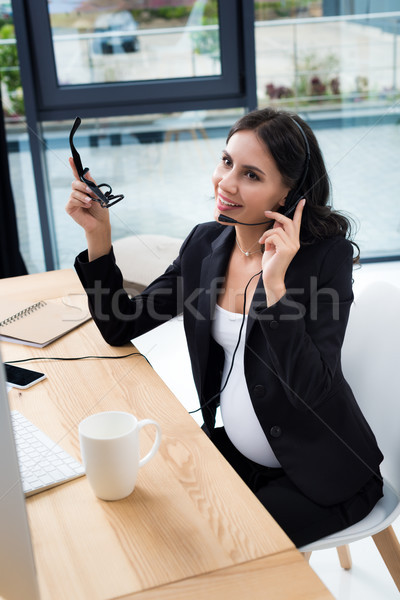 pregnant businesswoman with call center headset Stock photo © LightFieldStudios
