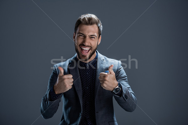Man in suit showing thumbs up Stock photo © LightFieldStudios