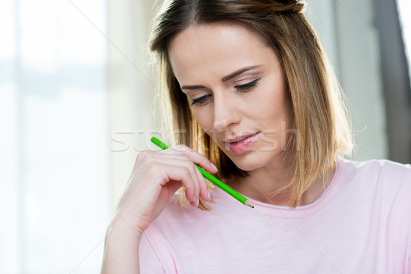 Stock photo: portrait of pensive woman with pencil at home