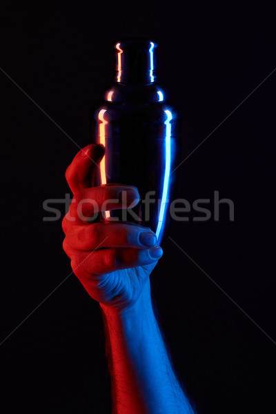 Stock photo: cropped shot of man holding cocktail shaker under toned light isolated on black