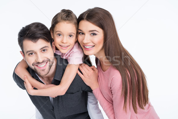 Happy young family with one child smiling at camera on white Stock photo © LightFieldStudios