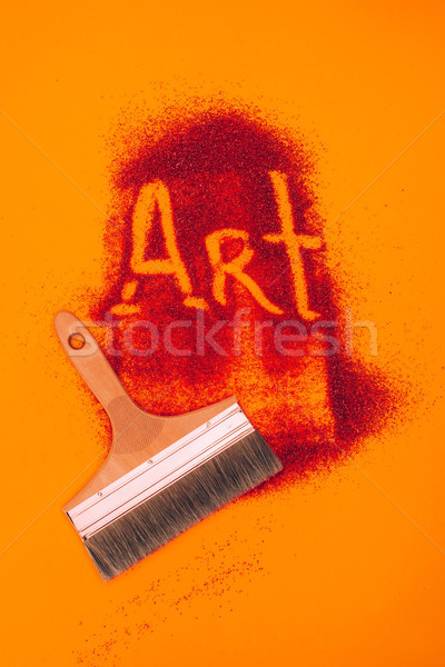 top view of art sign made of red sand and brush isolated on orange Stock photo © LightFieldStudios