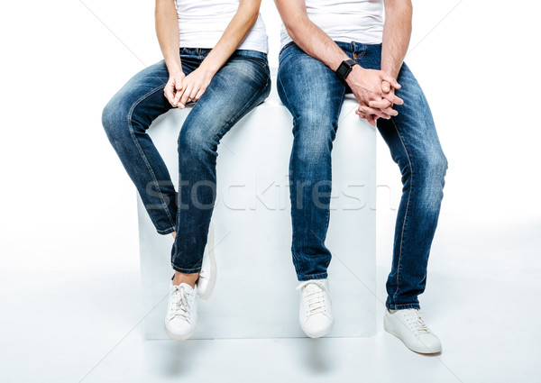 Couple sitting in jeans and white shoes Stock photo © LightFieldStudios