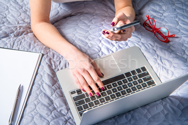 Kobieta za pomocą laptopa widoku młoda kobieta smartphone Zdjęcia stock © LightFieldStudios