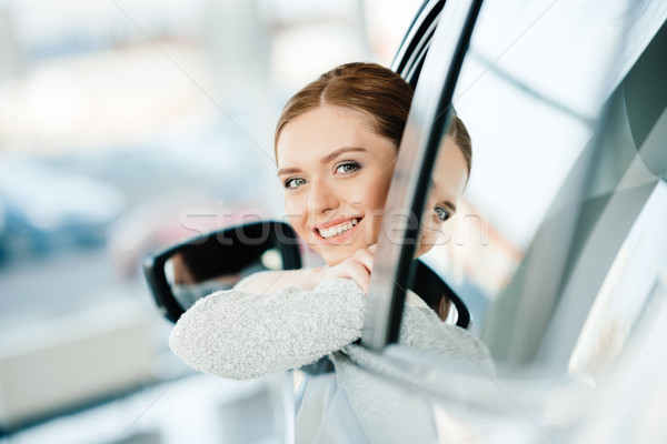 Happy young woman looking out window of new car Stock photo © LightFieldStudios