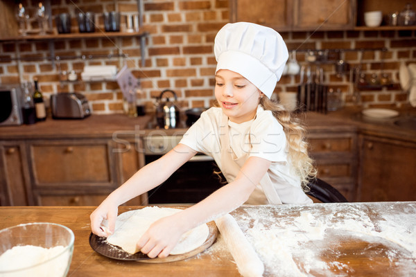little girl making pizza dough on wooden tabletop in kitchen  Stock photo © LightFieldStudios