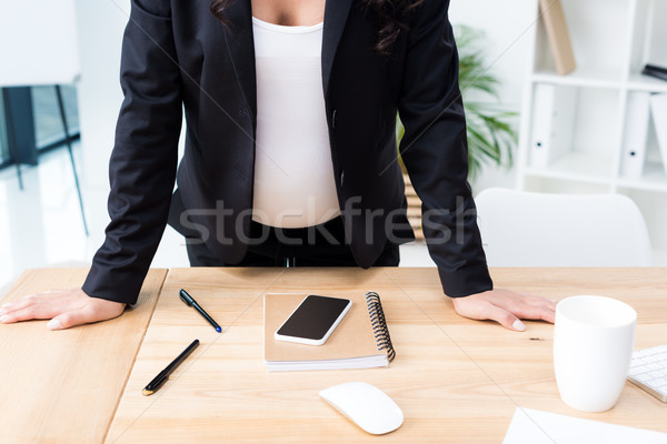 pregnant businesswoman leaning on desk Stock photo © LightFieldStudios