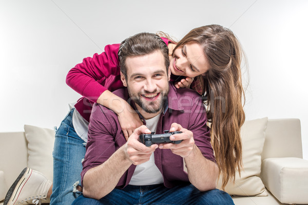 Woman hugging man playing with joystick Stock photo © LightFieldStudios
