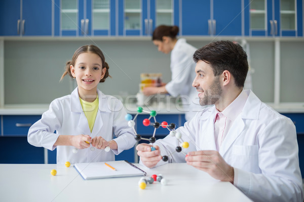 Stock photo: Smiling teacher and student scientists working with molecular model in lab