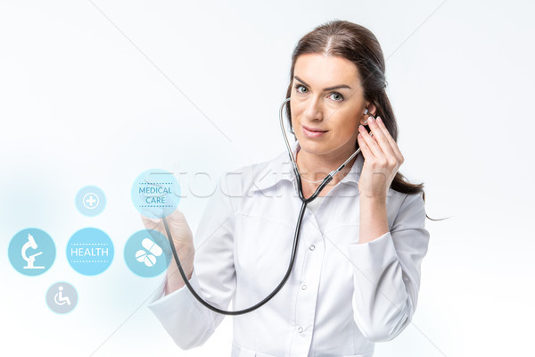 doctor with stethoscope and medical care icons Stock photo © LightFieldStudios