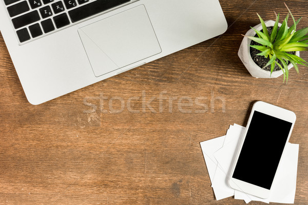 Close-up view of laptop and smartphone with blank screen on wooden table top, wireless communication Stock photo © LightFieldStudios