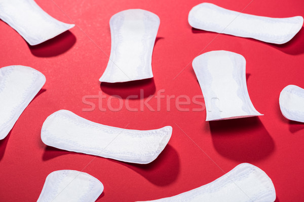 scattered protective daily pads on red Stock photo © LightFieldStudios