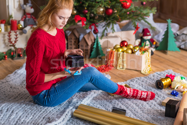 Girl wrapping gift box Stock photo © LightFieldStudios