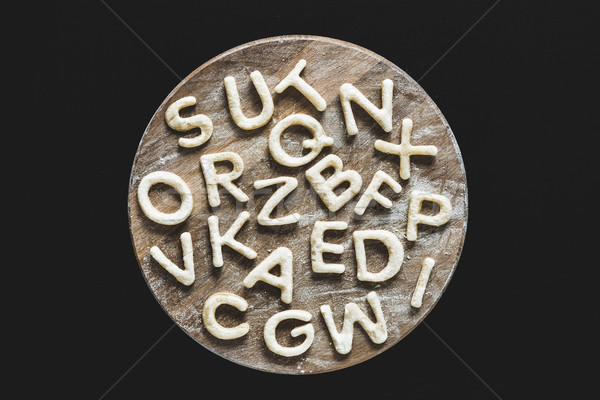 Top view of edible letters from dough on wooden cutting board, baking cookies concept Stock photo © LightFieldStudios