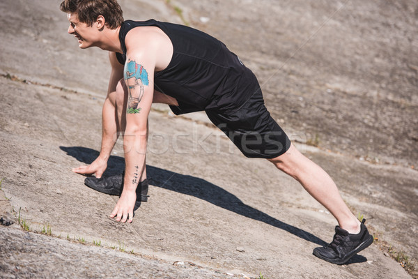 man stretching on slabs Stock photo © LightFieldStudios