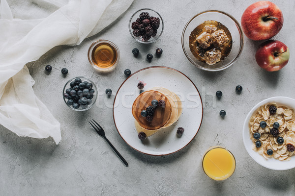 top view of healthy breakfast with homemade pancakes, fresh fruits and honey on grey Stock photo © LightFieldStudios
