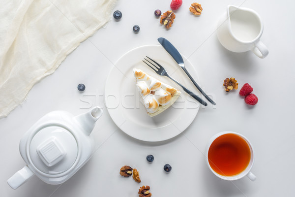 Stock photo: top view of piece of cake with berries and tea on white table