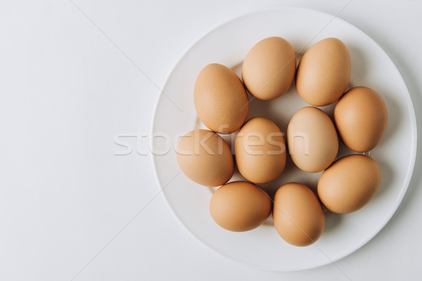 brown eggs laying on white plate on white background  Stock photo © LightFieldStudios