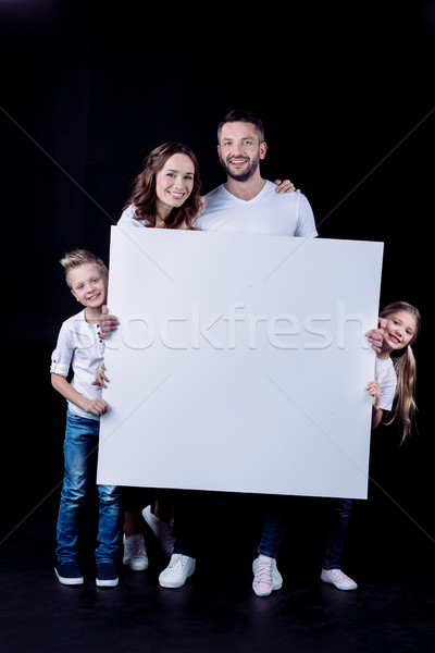 Smiling family holding blank card Stock photo © LightFieldStudios